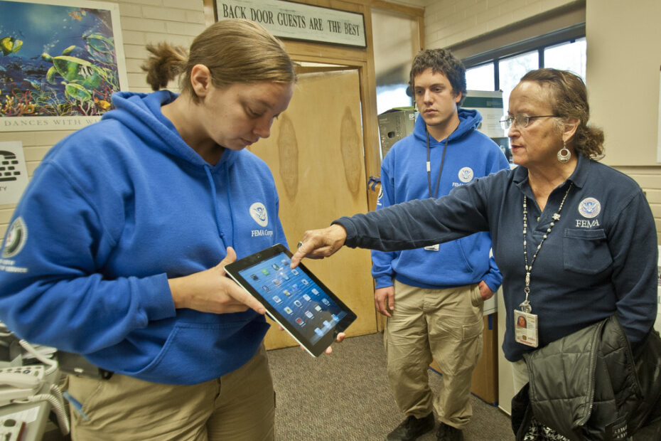 Nederland, CO, October 16,2013-Karen Bogenberger, a FEMA Corp Disaster Survivor Assistance disability communications specialist demonstrates an application (app) which can be used by a hearing impaired or voice disabled individual to a FEMA Individual Specialist at a DRC in Nederland, CO. FEMA provides a variety of services to insure that all residents are able to register and to get information they need to assist with their recovery from recent flooding. FEMA is working with local, state and other federal agencies to assist residents in Colorado who were affected by flooding. Photo by Patsy Lynch/FEMA
